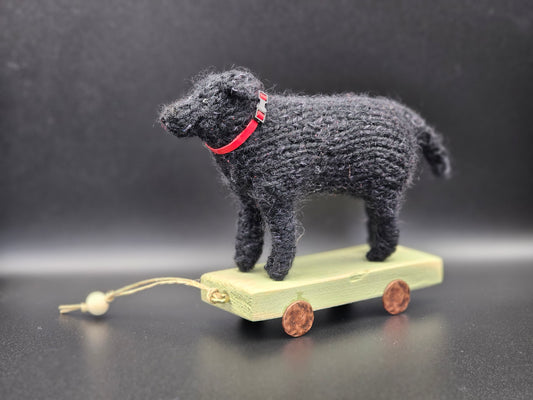 Handgebreide klassieke zwarte Labrador Retriever op houten kar