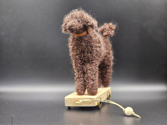 Handgebreide poedel op houten kar