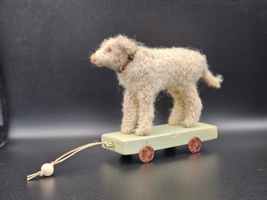 Handgebreide terriër op houten kar