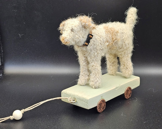 Handgebreide lichte terriër op houten kar