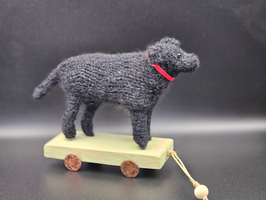 Handgebreide klassieke zwarte Labrador Retriever op houten kar
