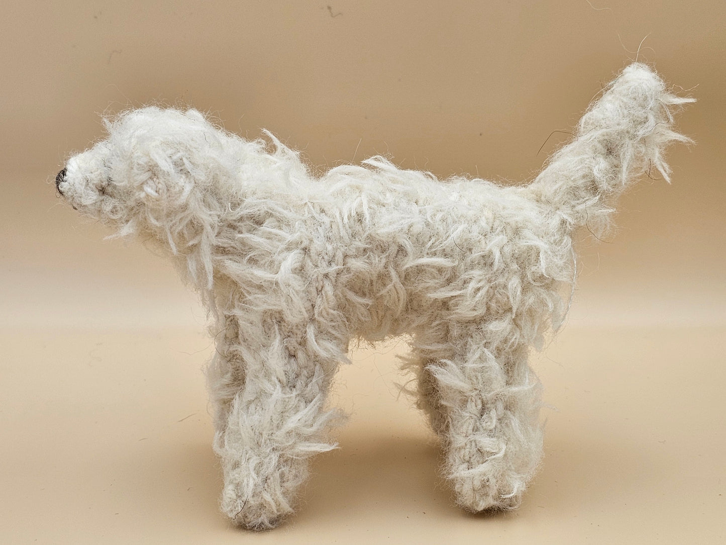 Fluffy handknitted hairy off white Labradoodle with movable head, legs and tail.