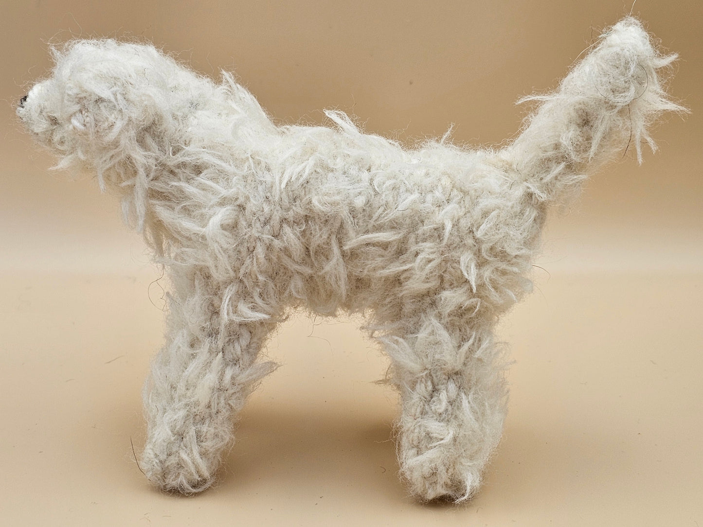 Fluffy handknitted hairy off white Labradoodle with movable head, legs and tail.